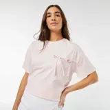 Camiseta rosa de manga corta con bolsillo en el pecho y lazos decorativos.