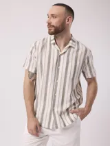 Camisa de manga corta con rayas verticales en tonos beige, blanco y gris. Confeccionada en lino y poliéster, con cuello clásico y bolsillo en el pecho.