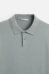 Polo color crema de manga larga con cuello solapa y cierre frontal de botonadura.