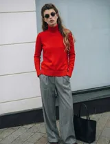 Polera de punto fino marca Nienty, color blanco, con cuello alto volcado y mangas largas con detalle de tajo en los puños.