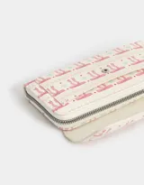 Billetera tipo fichero con estampado de moños rosas y celestes sobre fondo blanco. Tiene cierre superior y solapa con broche.