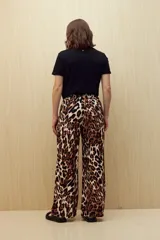 Pantalón ancho de tela liviana con estampado de hojas color crema sobre fondo azul. Tiene cintura elastizada con lazo ajustable.