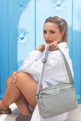 Bandolera color beige con correa de galón a tono, dos bolsillos frontales con cierre y uno dorsal. Su bolsillo principal incluye reparticiones internas.