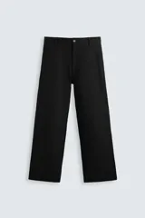 Pantalón negro de algodón con corte relajado y pierna ancha (flare fit). Presenta cierre frontal con botón y cremallera, bolsillos delanteros y bolsillos traseros de plastrón.