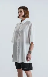 Camisa blanca de corte amplio con mangas cortas.