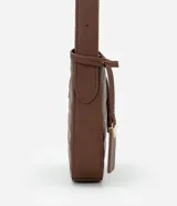 Bolso baguette pequeño color marrón con textura en relieve, correa ajustable, cierre por cremallera y solapa con detalle de colgante en el lateral.