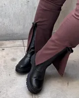 Bota de caña media color chocolate oscuro, realizada en cuero encerado. Con elástico italiano en la caña de ambos lados y fondo artesanal de suela color negro. El interior está forrado en forrería vacuna.