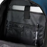 Mochila Rip Curl modelo Posse Cool de 33 litros, color azul oscuro con base negra. Presenta un panel frontal con franjas horizontales degradadas en tonos cálidos (naranja, amarillo, verde). Incluye correas de compresión frontales con hebillas de plástico negro y un llavero con forma de tabla de surf.