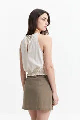 Blusa sin mangas color ladrillo, con cuello halter y elástico en el cuello y la cintura.