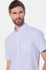 Camisa celeste de lino y algodón, de manga corta, con cuello abotonado y bolsillo en el pecho.