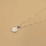 Conjunto de collar y dije en plata 925 con dije circular de nácar.