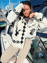 Camperón tejido oversize con capucha, bolsillos y estampa de ciervo.