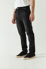 Jean negro de corte slim, con tiro medio, cinco bolsillos y cierre con cremallera y botón. Confeccionado en denim de algodón con spandex.