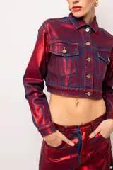Campera corta de jean tornasolada en tonos rojo, azul y bordó, con cuello clásico, cierre frontal con botones dorados, bolsillos con solapa en el pecho y mangas largas.