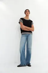 Top negro de tejido de punto con cuello redondo y mangas cortas con ribete blanco.