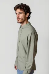 Camisa blanca de manga larga con cuello clásico y cierre frontal con botones.