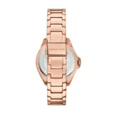 Reloj Michael Kors modelo Kacie, con caja y pulsera de acero inoxidable color oro rosa. Bisel con cristales incrustados, esfera plateada con números romanos y movimiento de cuarzo de tres agujas.