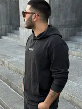 Buzo negro stonewashed con capucha, corte boxy y logo albm bordado en el pecho.