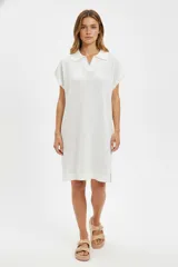 Vestido blanco de algodón calado, corte a la rodilla, holgado, con cuello camisero y mangas cortas.