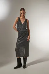 Falda midi dorada con lentejuelas y abertura lateral.