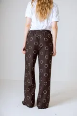 Conjunto de camisa y pantalón marrón con estampado de círculos blancos.