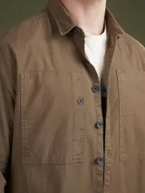 Camisa color marino, de corte clásico, con botones al frente y dos bolsillos en el pecho.