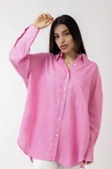 Camisa de lino color rosa con cuello clásico, cierre frontal con botones y mangas largas con puños abotonados.