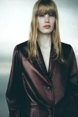 Blazer de cuero color marrón chocolate con cuello solapa, cierre frontal con dos botones, bolsillos de vivo y abertura en la espalda.