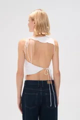 Top sin mangas blanco de poliéster, con lazo y cuello redondo.