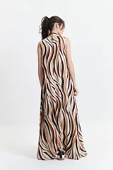 Vestido largo con estampado abstracto en tonos marrón, negro y blanco, escote en V y corte suelto.