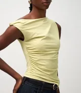 Blusa sin mangas color amarillo claro, confeccionada en microfibra, con escote asimétrico de un solo hombro, detalle torcido en el hombro y fruncidos en el cuerpo. Presenta un bajo asimétrico.