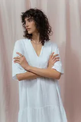 Vestido blanco de lino, corte holgado, con escote en V y mangas cortas.