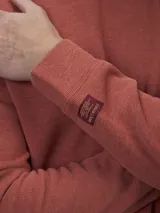 Buzo de frisa color gris topo, de corte clásico y cuello redondo.