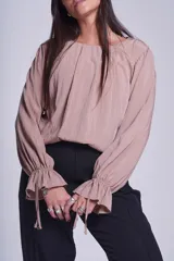 Blusa negra de manga larga con cuello a la base y puños con elástico.