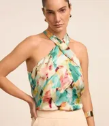 Blusa sin mangas con cuello halter con lazo, cavas americanas y estampa abstracta con efecto satinado.