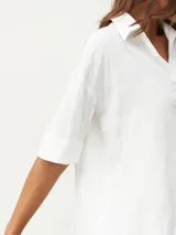 Camisa blanca de mangas cortas con textura.
