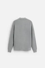 Polo marrón de punto con hilatura de algodón, corte relaxed fit, cuello solapa con cierre frontal de botonadura, manga larga y acabados en rib.