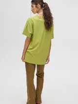 Remera amarilla de corte cuadrado y holgado, con estampado de estrella plateada con borde negro en el frente.