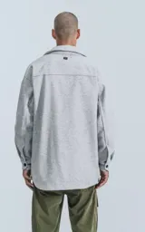 Chaqueta gris melange de paño con cuello clásico, cierre frontal con botones negros, dos bolsillos de parche en el pecho y dos bolsillos laterales.