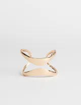 Brazalete rígido dorado con diseño geométrico abierto.
