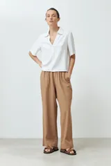 Blusa blanca de lino con cuello camisero y mangas cortas.