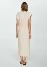Vestido color crema de tejido fluido, con cuello camisero, mangas cortas con vuelta, detalles drapeados, diseño midi y entallado, y cierre delantero de botones oculto.