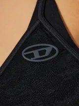 Combinación tipo slip dress corta de encaje negro, con escote en V tanto en el frente como en la espalda y tirantes finos.