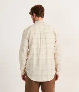 Camisa masculina regular de lino y algodón, color beige claro con estampado de cuadros grises. Tiene cuello inglés, mangas largas y abotonadura frontal.