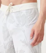 Bermuda de poliéster blanca con estampado de hojas en tonos grises.
