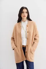 Tapado color beige de tejido de hilado suave y mullido, con calce relajado, mangas largas, cuello redondo y botones a tono.