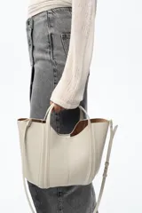 Bolso mini city color marrón con asa de mano y asa bandolera extraíble. Incluye bolsa interior extraíble con cierre mediante cremallera.