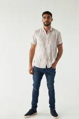 Camisa de hombre estampada, de manga corta y fit slim. Presenta cartera abotonada y logo bordado.