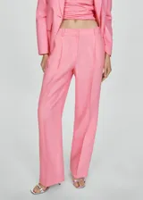 Pantalón de lino color rosa, de corte recto y tiro bajo, con pinzas, bolsillos laterales y trabillas. Cierre frontal oculto con botón, gancho y cremallera.