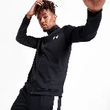 Conjunto deportivo Under Armour de hombre, compuesto por campera y pantalón de acetato negro con detalles de rayas blancas en mangas y laterales. La campera tiene cuello alto, cierre frontal y logo bordado en el pecho. El pantalón tiene cintura elástica con cordón ajustable y logo bordado en la cadera.